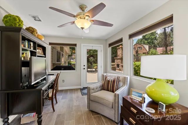 a living room with furniture a flat screen tv and a large window