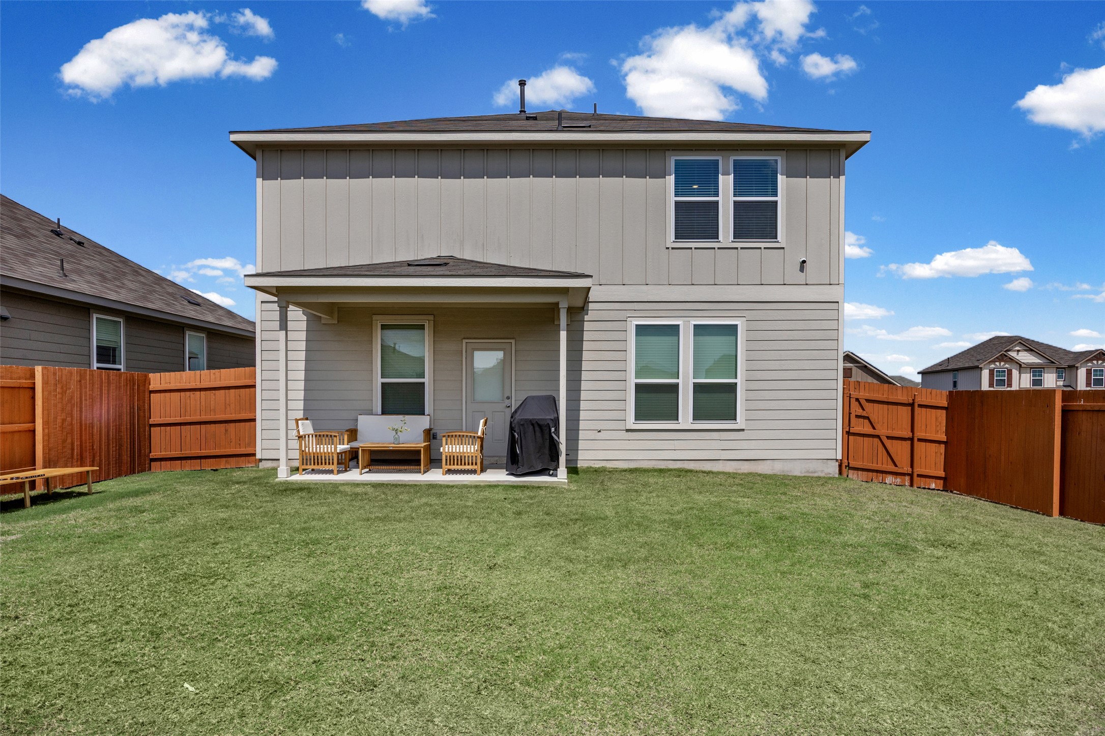 208 Orange Road Buda, TX 78610 - Photo 23 of 31 A generous grassy backyard awaits with a covered patio perfect for outdoor enjoyment.