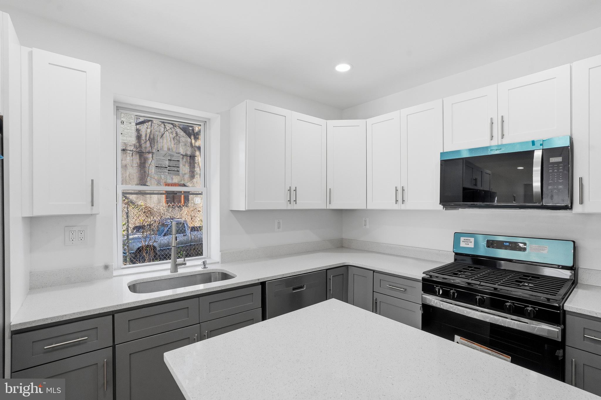 1281 Jackson Street Camden, NJ 08104 - Photo 14 of 43 a kitchen with a sink a stove and microwave