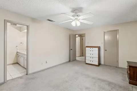 an empty room with closet and a chandelier fan