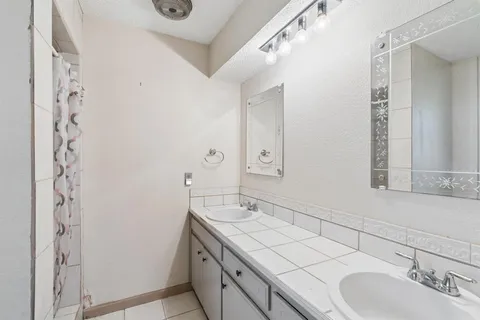 a bathroom with a double vanity sink and a mirror