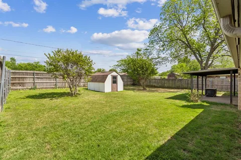 a view of a house with backyard and a garden