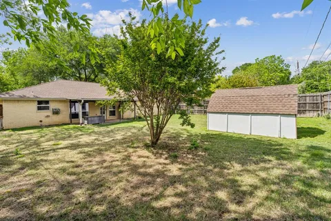 a backyard of a house with table and chairs