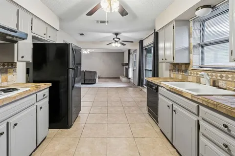 a kitchen with a sink a refrigerator and cabinets