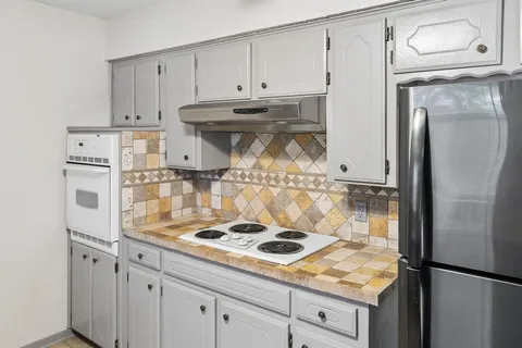 a kitchen with refrigerator and cabinets