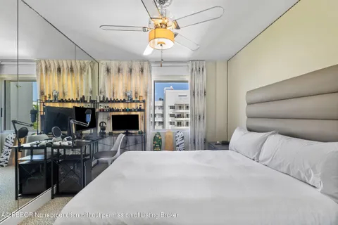 a bed room with a bed mirror and a chandelier