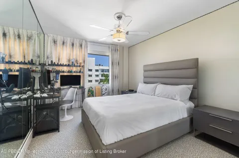 a bed room with a bed couch and a ceiling fan