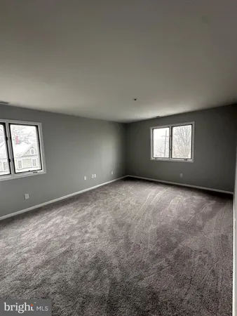 an empty room with a empty space and windows