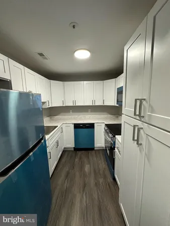 a kitchen with granite countertop stainless steel appliances a sink refrigerator and microwave