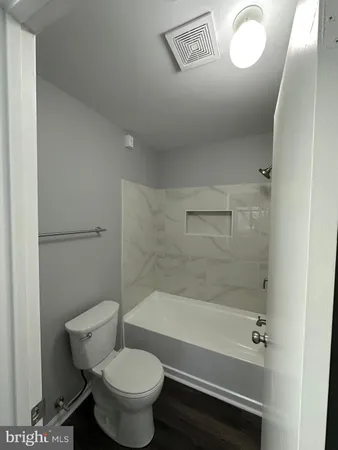 a bathroom with a toilet and a bath tub