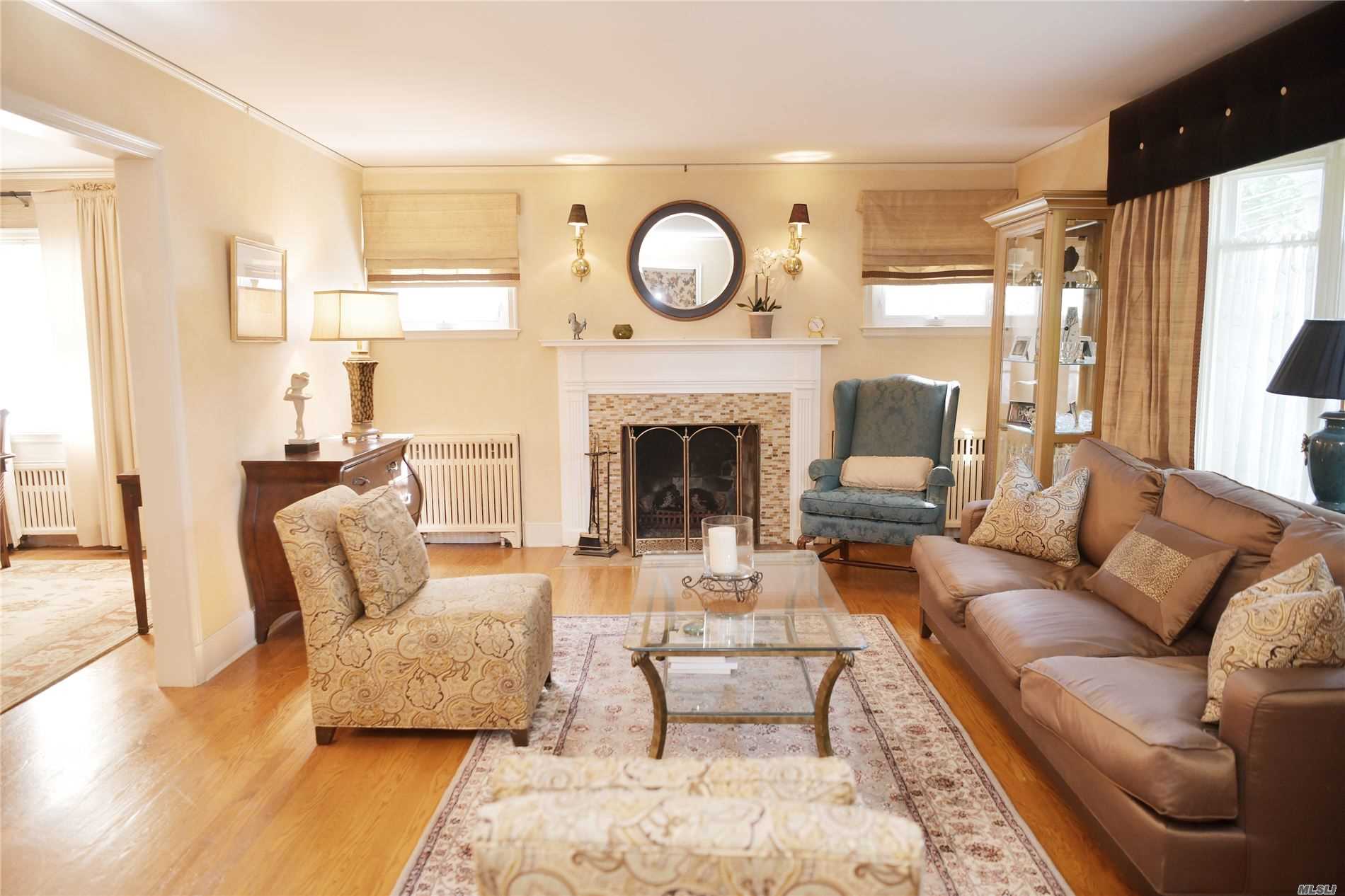 a living room with furniture a fireplace and a large window