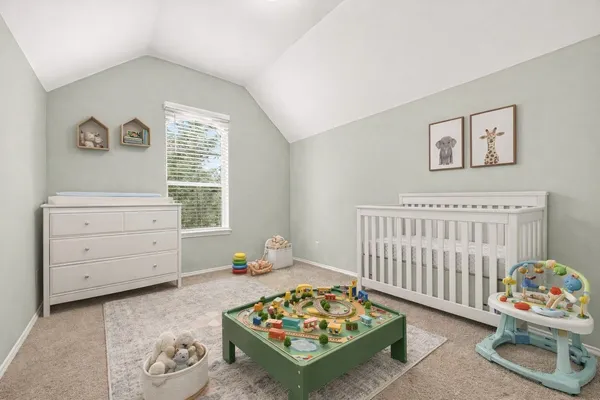 a bedroom with a baby bed a dresser and a window