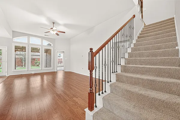 a view of a livingroom with wooden floor and stairs
