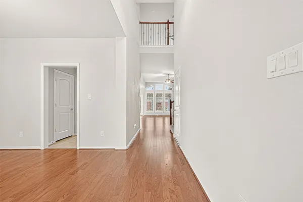 a view of a hallway with wooden floor and staircase