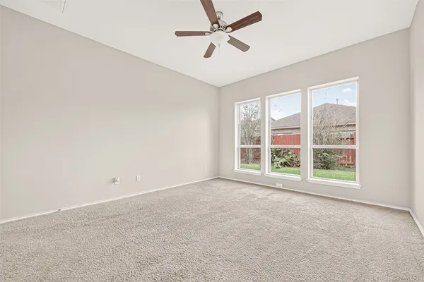 an empty room with a window and a fan