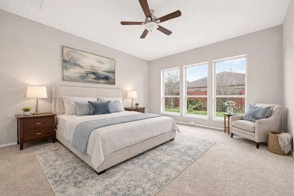 a spacious bedroom with a bed and a large window
