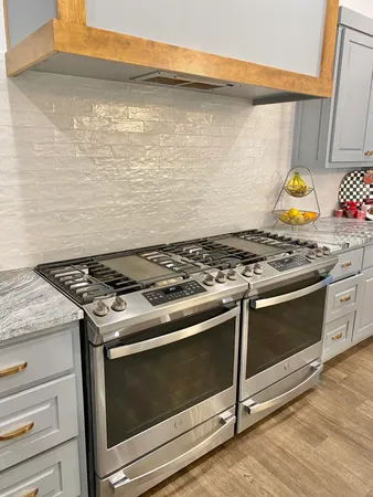 a stove top oven sitting inside of a kitchen
