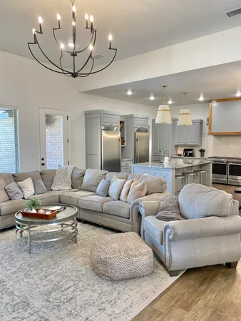 a living room with furniture kitchen and a chandelier