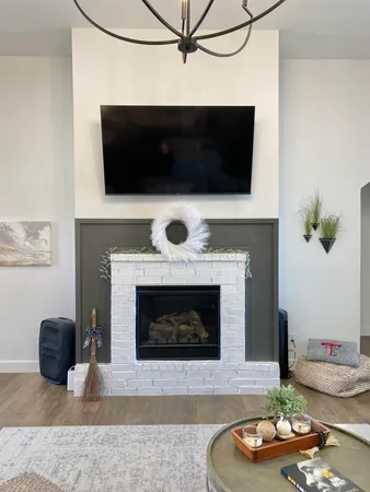 a living room with furniture a fireplace and a flat screen tv