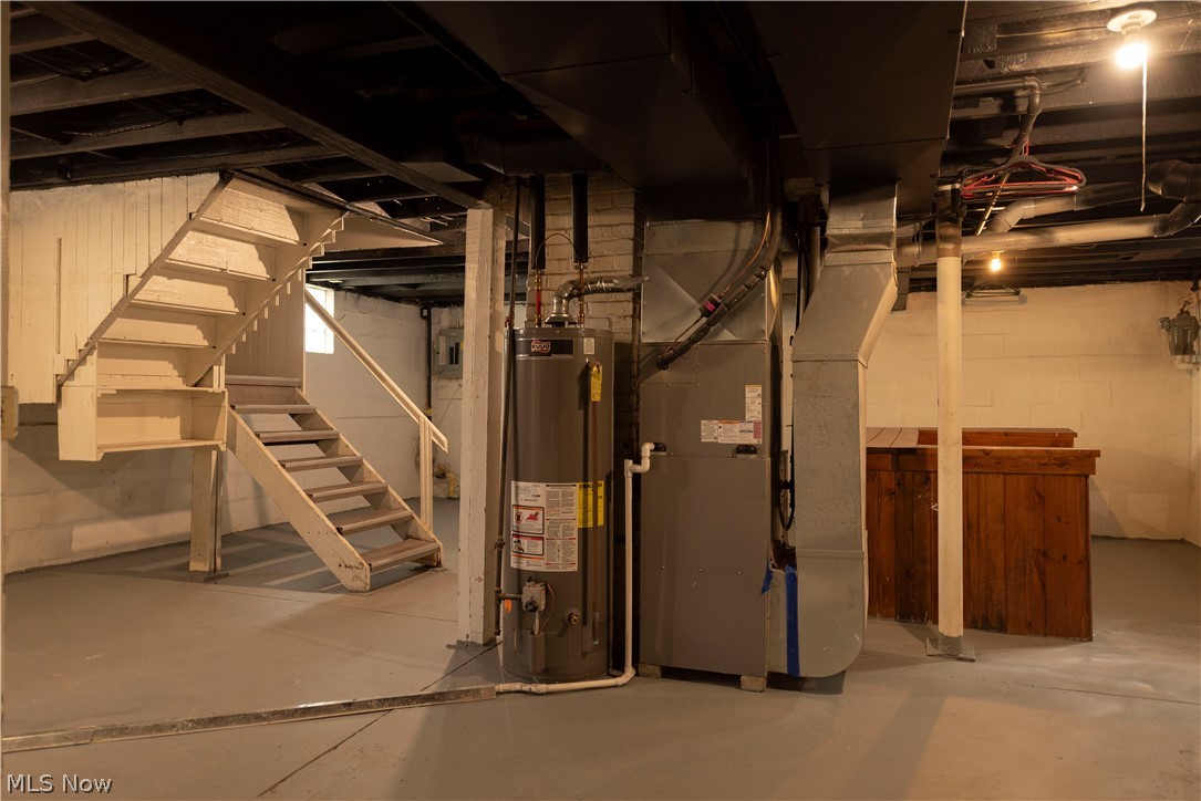 1022 North Howard Street Akron, OH 44310 - Photo 34 of 38 Basement featuring 2018 hot water tank, stairway, and new high efficiency furnace with AC and condensate line.