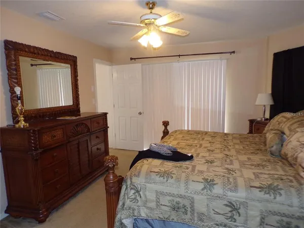 a bedroom with a bed and a mirror on dresser