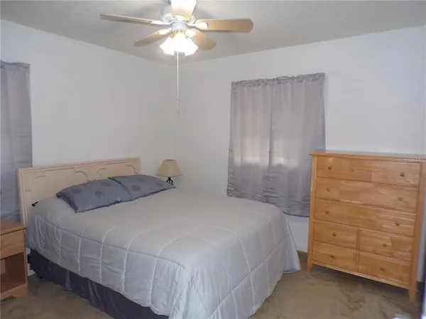 a bedroom with a bed and a ceiling fan