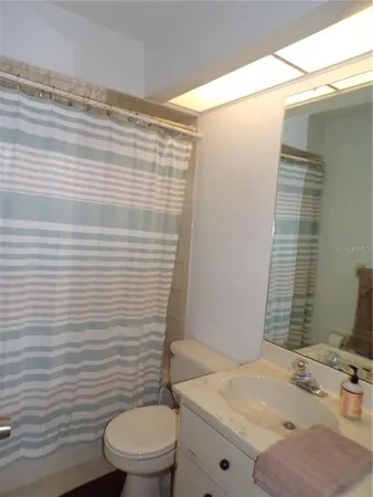 a bathroom with a sink a toilet and shower curtain