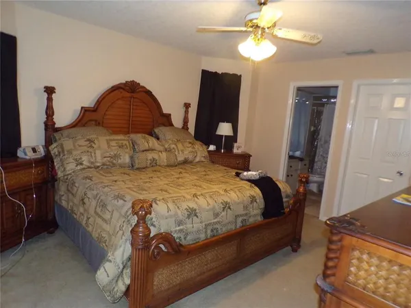 a spacious bedroom with a bed and a chandelier