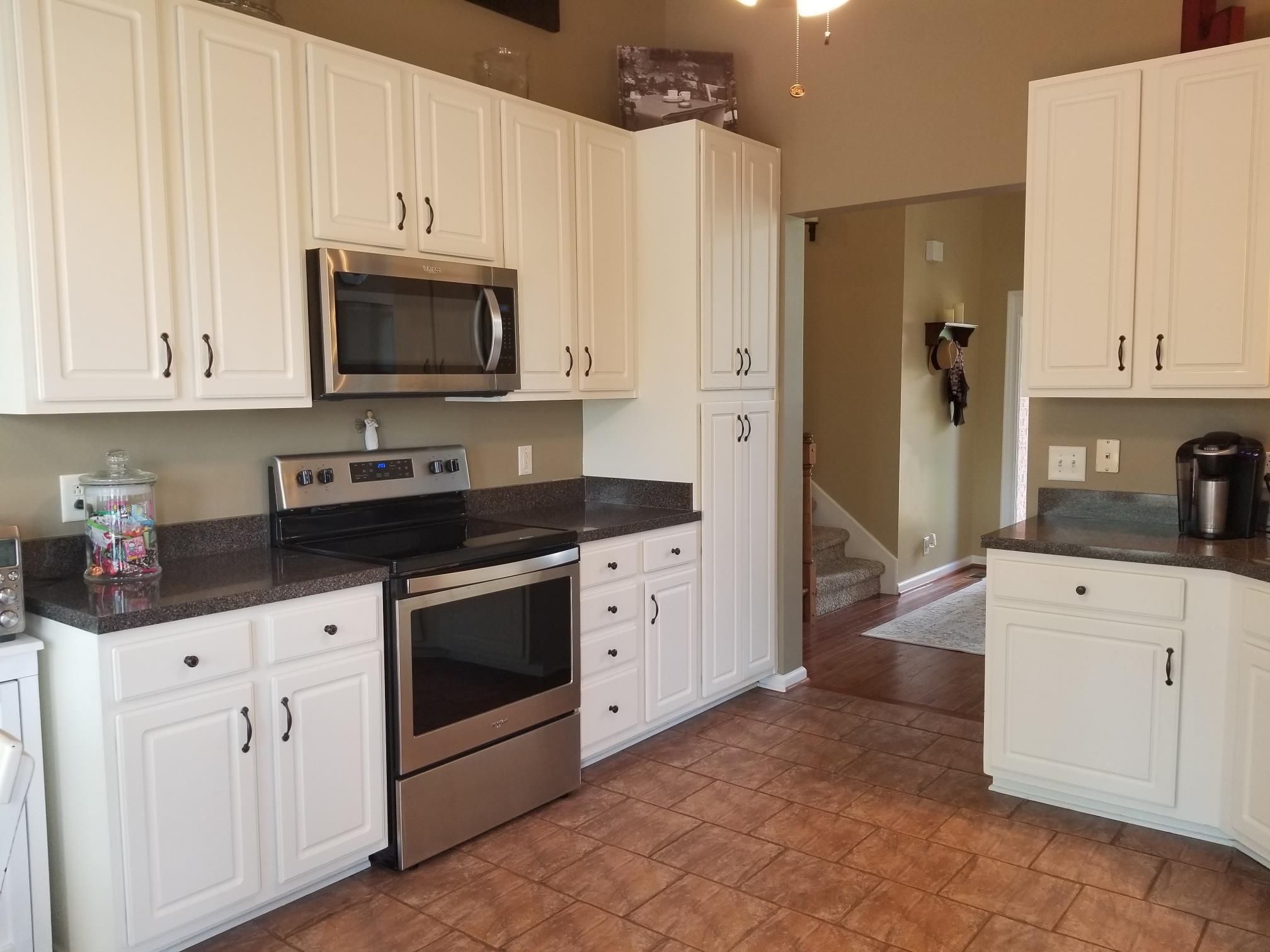 5249 Ridgefalls Way Antioch, TN 37013 - Photo 6 of 23 a kitchen with white cabinets and stainless steel appliances