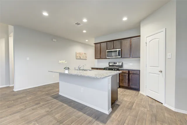 a kitchen with stainless steel appliances granite countertop a sink stove and refrigerator
