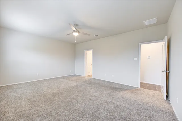 an empty room with fan and windows