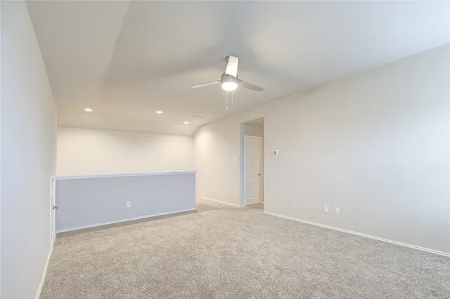 an empty room with an entryway and fan