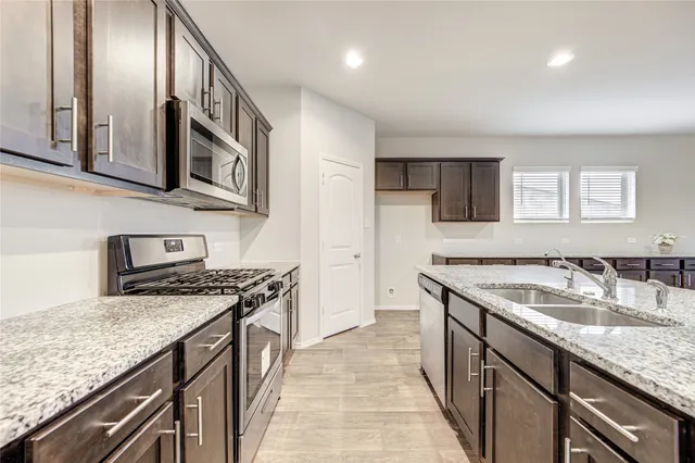a kitchen with stainless steel appliances granite countertop a sink and stove