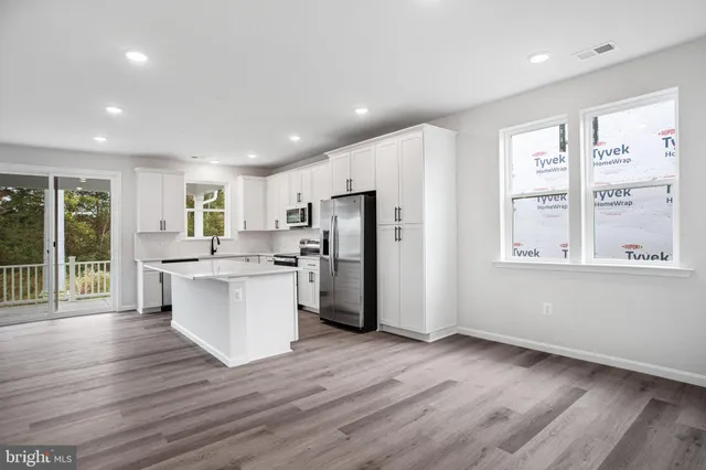 a kitchen with a refrigerator and white cabinets