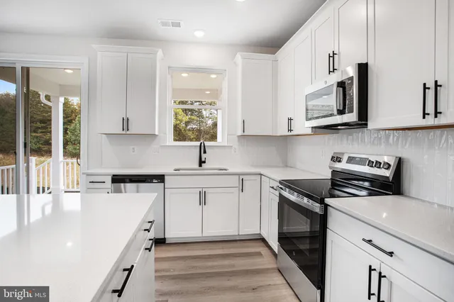 a kitchen with stainless steel appliances granite countertop a sink and a stove