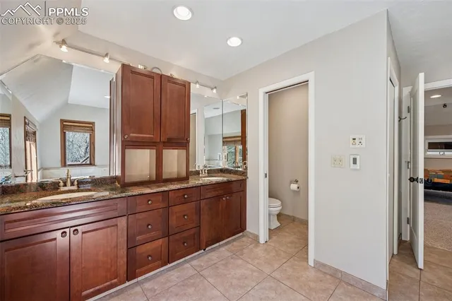 a spacious bathroom with a granite countertop sink mirror and toilet