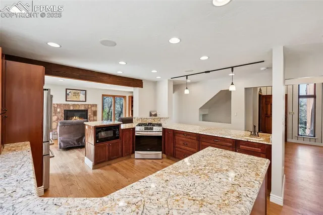 a living room with stainless steel appliances kitchen island granite countertop furniture wooden floor and a view of kitchen