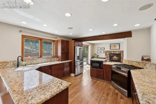 a kitchen with stainless steel appliances granite countertop a stove a sink and a refrigerator