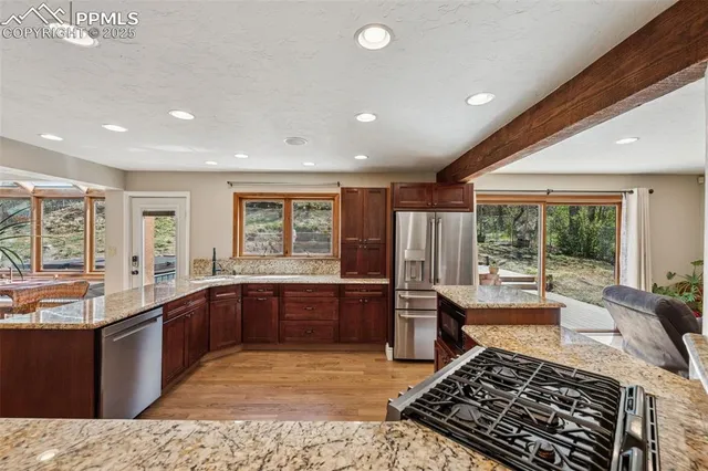 a large kitchen with kitchen island granite countertop a large window in it
