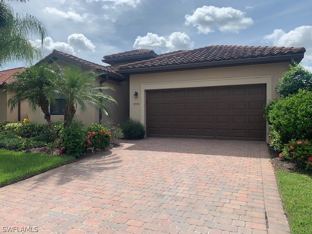 8976 Water Tupelo Road Fort Myers, FL 33912 - Photo 2 of 35 a front view of a house with a garage