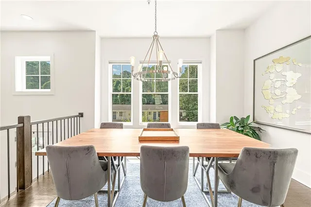 a dining room with furniture large windows and wooden floor