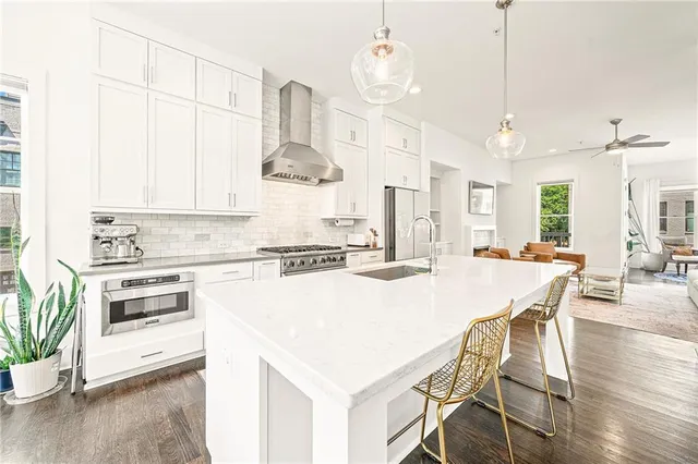 a kitchen with stainless steel appliances kitchen island a stove a table and chairs in it