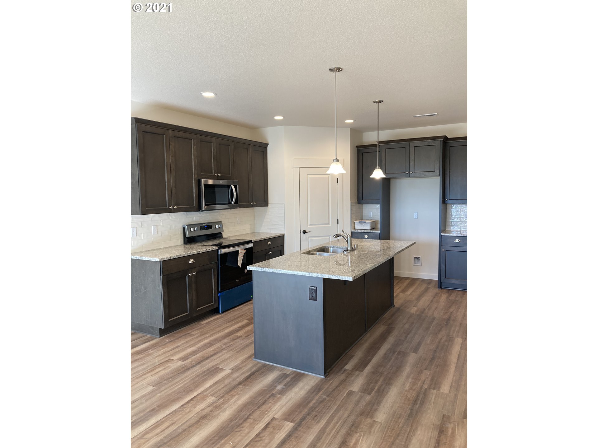 1227 South Union Place Ridgefield, WA 98642 - Photo 2 of 8 a large kitchen with a sink and stainless steel appliances