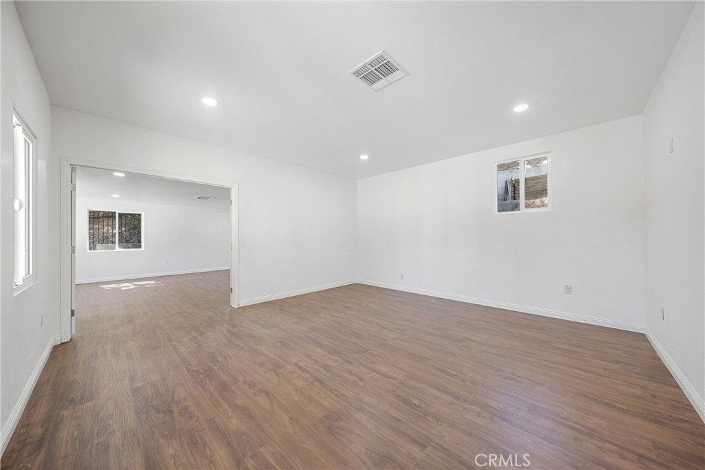 26251 Ravenhill Road Canyon Country, CA 91387 - Photo 13 of 64 a view of an empty room with wooden floor and a window