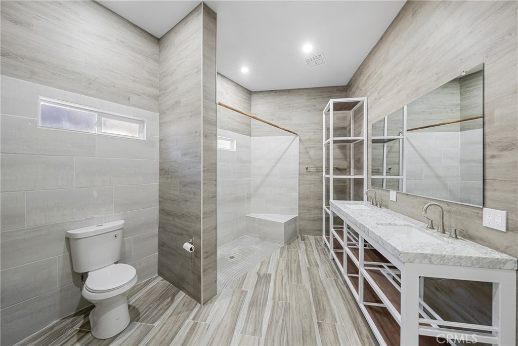 26251 Ravenhill Road Canyon Country, CA 91387 - Photo 16 of 64 a bathroom with a granite countertop sink toilet and shower