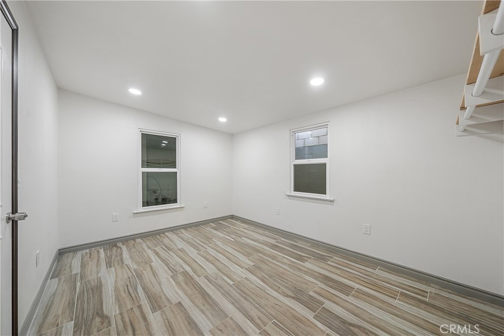26251 Ravenhill Road Canyon Country, CA 91387 - Photo 22 of 64 an empty room with wooden floor and windows