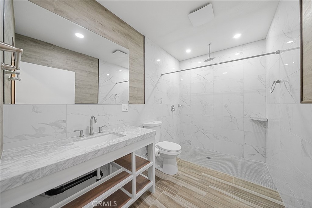 26251 Ravenhill Road Canyon Country, CA 91387 - Photo 23 of 64 a bathroom with a sink a toilet a mirror and shower