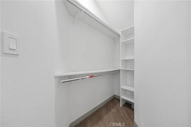 a view of an empty room with wooden floor and closet