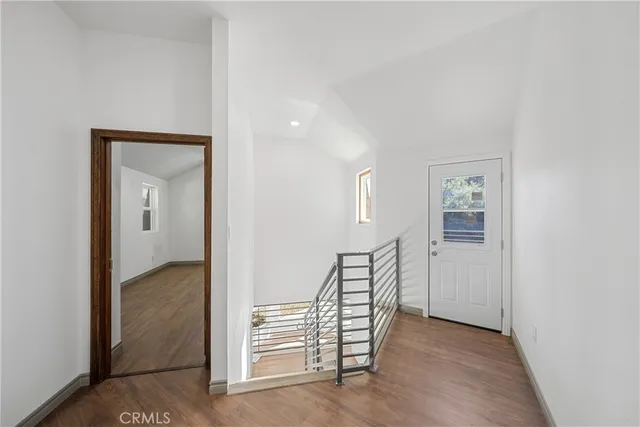 a view of empty room with wooden floor and window