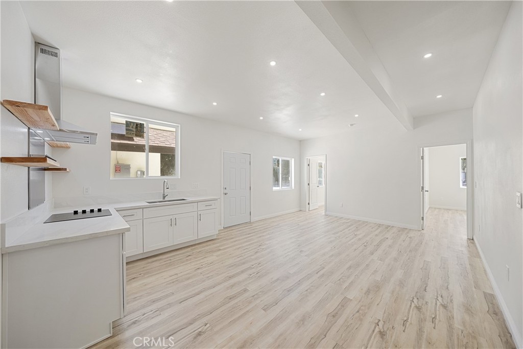 26251 Ravenhill Road Canyon Country, CA 91387 - Photo 34 of 64 a large white kitchen with stainless steel appliances a large counter top a sink and a refrigerator